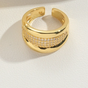 Detail of wide gold open ring featuring multi-row pave-set cubic zirconia stones