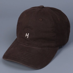 Close-up of vintage washed cotton fabric and embroidered letter H on dark brown baseball cap