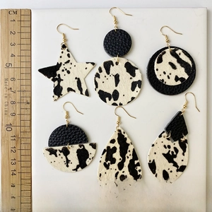 Boucles d'oreilles en cuir de vachette en forme d'étoile avec motif vache noir et blanc