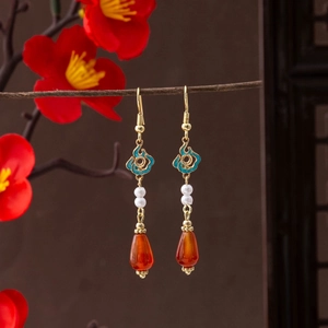 Detail of red teardrop bead and enamel auspicious cloud on classic Chinese earrings