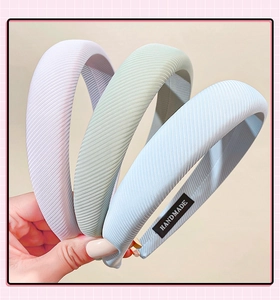 Detailed texture of three ribbed sponge headbands in light purple, green, and blue colors