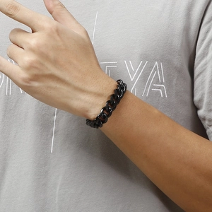 Polished black titanium steel Cuban link bracelet worn on wrist for a stylish look