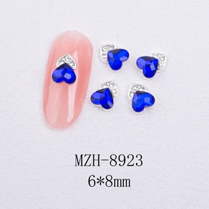 Macro view of 6x8mm heart-shaped blue cat-eye nail art charms with silver diamond base