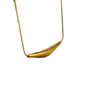 Collier chaîne serpent dorée minimaliste avec pendentif incurvé sur fond blanc pur