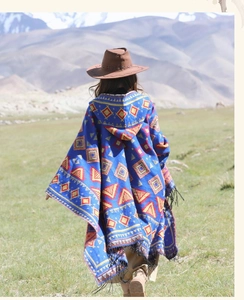 Poncho bleu ethnique à motifs géométriques colorés et franges dans les hauts plateaux