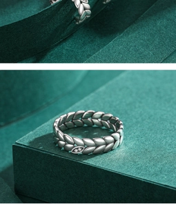 Macro detail of S925 silver leaf ring with sparkling crystals on a textured green background