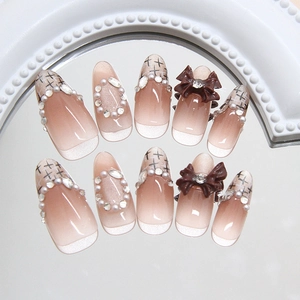 Pink cat-eye press-on nails with 3D bows, pearls, and rhinestones on mirrored base