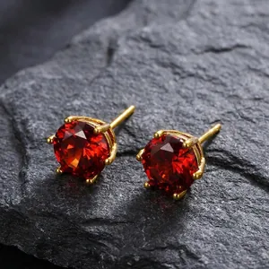 Macro detail of red cubic zirconia earrings with 24k gold plating in six-prong setting