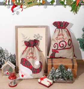Detailed view of rustic burlap Christmas drawstring bags with Santa and reindeer motifs