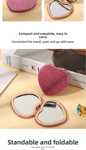 Detailed view of a pink glitter heart-shaped folding travel mirror with gold metal trim