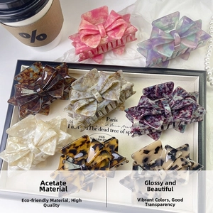 Collection of premium acetate bow hair claws in various marble and tortoiseshell patterns