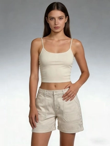 Dettaglio degli shorts cargo in denim beige con cuciture a vista e tasche laterali