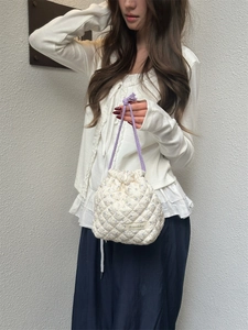 Quilted floral drawstring bag detail showing purple flower pattern and textured cotton fabric