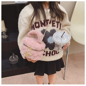 Detail of pink faux fur bucket bag featuring golden rose charm and metal chain strap