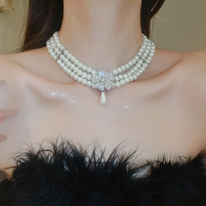 Detail shot of three-row pearl choker necklace with crystal flower and teardrop pendant