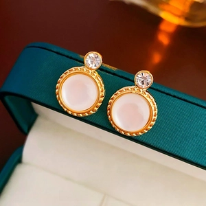 Detailed close-up of French vintage gold twist earrings with white stone and zircon