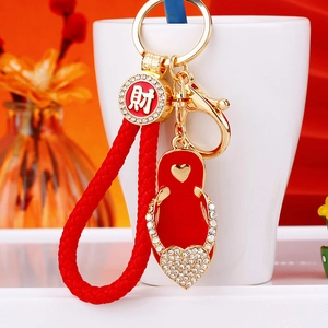 Detailed close-up of a red flip-flop charm keychain with rhinestones and golden metal hook