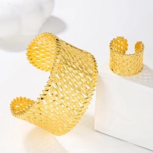 Detailed view of gold-plated hollow cuff bracelet and matching ring set for bridal wear