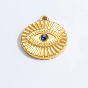 Detailed view of a gold Evil Eye pendant with blue stone inlay and radial textures
