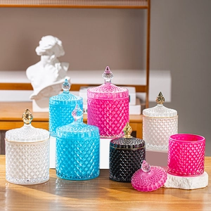 Detailed view of diamond-textured glass storage jars in transparent, blue, pink, and black