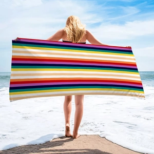Detailed view of a large colorful striped beach towel held by a model on a sunny beach