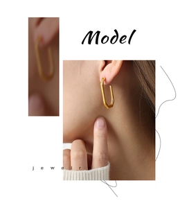 Macro detail of elegant gold plated u-shaped geometric earrings on model showing metal texture