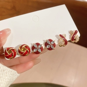 Detailed view of three pairs of vintage red and gold enamel earrings with sparkling crystals