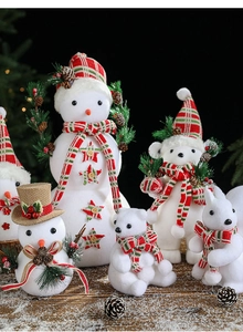 Detail of white flocked snowman and polar bear figurines with festive plaid scarves