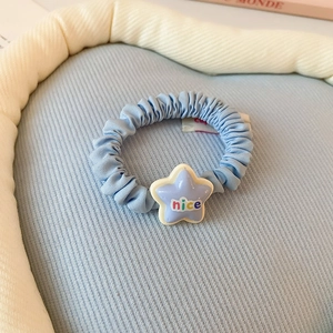 Gros plan sur chouchou bleu plissé avec pendentif étoile et inscription nice élégant