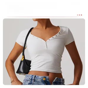Close-up of white cropped yoga shirt with V-neckline and silver buttons detailing