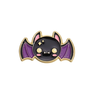 Close-up of cute Halloween enamel pin featuring a black bat with purple wings and gold edges