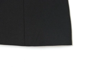 Gros plan sur la texture du tissu noir et les coutures détaillées de l'ourlet du haut