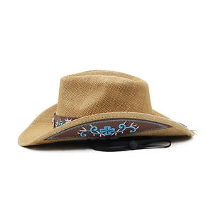 Retro cowboy straw hat with embroidered band and chin strap on white background