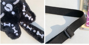 Detalle del bolso de felpa negra con bordado de hueso blanco y correa de lona ajustable