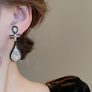 Detail von Vintage-Ohrhänger mit schwarzem Emaille und funkelnden Strasssteinen am Modell