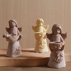 Three angel resin molds for candle holders and flower pots on a wooden tray