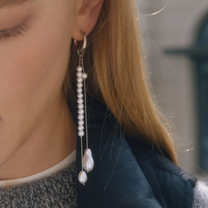 Elegant stainless steel tassel earrings with round and baroque pearls on female model