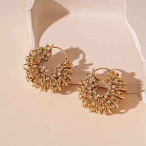 Détail macro de boucles d'oreilles en U dorées multicouches avec strass brillants