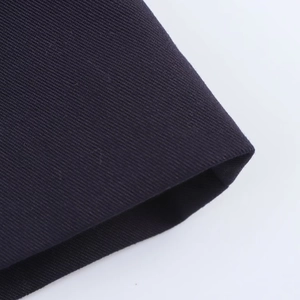 Vue macro du tissu en sergé bleu foncé montrant les coutures et la texture fine