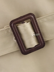 Detailed close-up of khaki trench coat belt with high-quality dark brown buckle