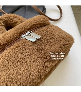 Detail view of brown faux shearling crossbody bag with premium metal dual zippers
