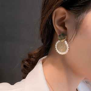 Orecchini a cerchio dorati con maglia e perle finte indossati in elegante stile francese