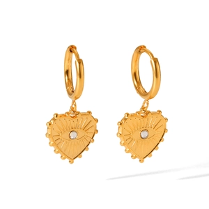 Macro shot of gold heart dangle earrings featuring white zircon and devil's eye detail