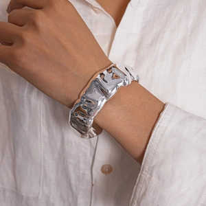 Detailed view of silver liquid wrinkle texture on a wide open cuff bangle bracelet