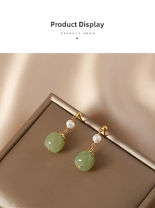 Detailed view of vintage freshwater pearl earrings with green beads on silk