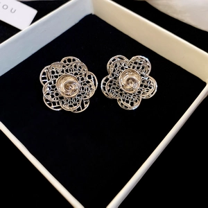 Elegant silver flower stud earrings with hollow petal design on black jewelry cushion