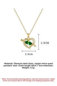 Detail of gold titanium heart necklace with green gems and Cupid arrow charm