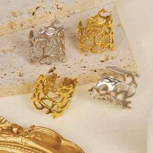 Detailed macro view of irregular hollow branch rings in gold and silver finish