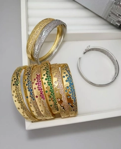 Vue macro de bracelets en or et argent sertis de zircons colorés sur un plateau