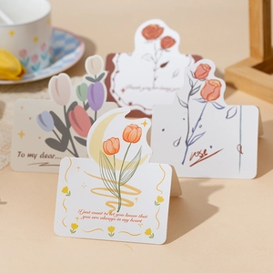 Detailed view of floral greeting cards with tulip and rose designs on a desk